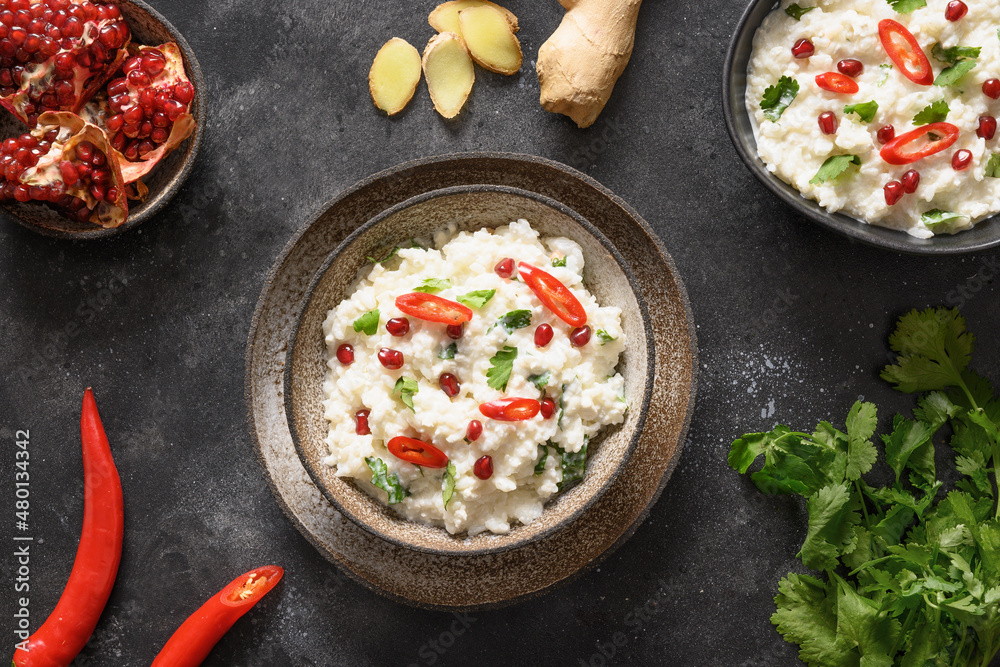 Curd rice with pomegranate, spicy, ginger on dark gray background. Top view. Indian cuisine. Curd rice with pomegranate, spicy, ginger on dark gray background. Top view. Indian cuisine.