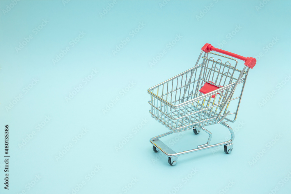 Empty shopping trolley with blue background Empty shopping trolley with blue background