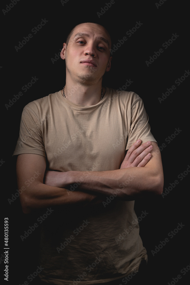 Handsome guy posing in studio on isolated black background. Studio portrait with one light source.