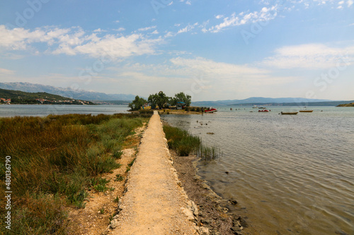 Schmaler Fu  weg   ber das Wasser zur Inselkirche von Novigrad in Dalmatien