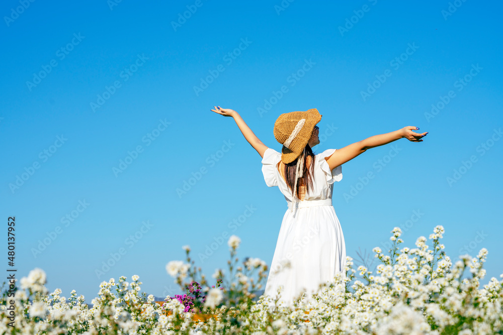 Freedom Girl jumping and enjoying life against the blue sky in the flower garden.