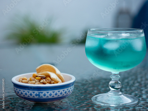 Canvas Blue gin and tonic with aperitifs in a glass cup with dew