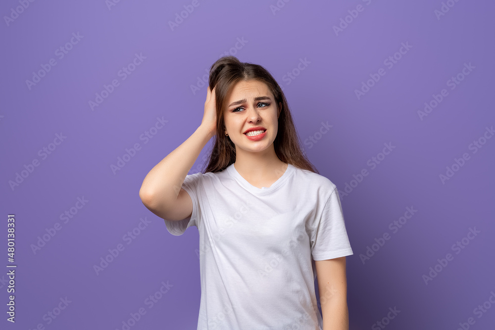 Young brunette girl wearing casual white tshirt surprised with hand on head for mistake, remember error, forgot, bad memory concept Young brunette girl wearing casual white tshirt surprised with hand on head for mistake, remember error, forgot, bad memory concept