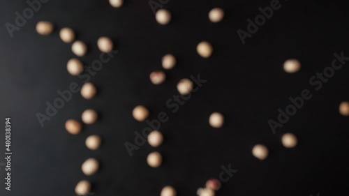 The hazelnut soars to the camera and falls down on a black background.