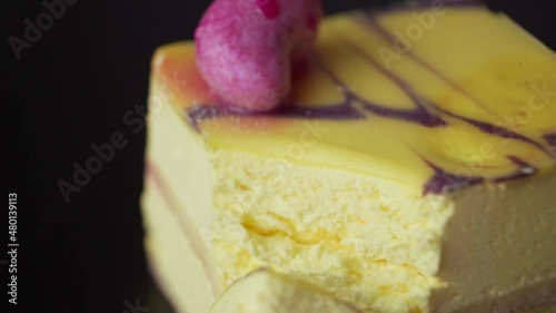 A piece of yellow dessert is broken off with a spoon, close-up, slow motion