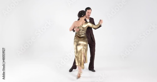 Man and women dancing tango. Professional dancers in elegant suit and gold dress on white background