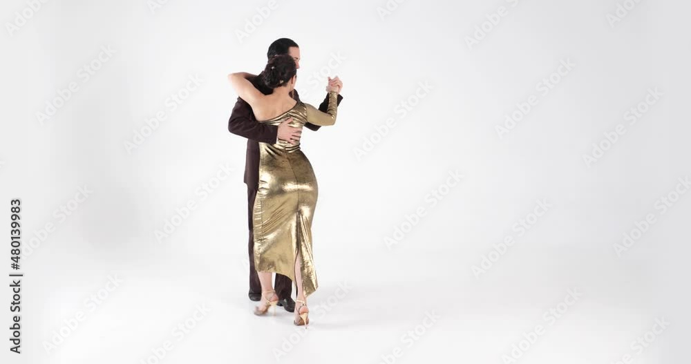 Couple of professional dancers in elegant suit and dress dancing tango on white background. Couple of professional dancers in elegant suit and dress dancing tango on white background.