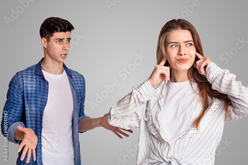 Quarrel and showdown. Sad woman covers her ears with fingers, upset man expresses negative emotions