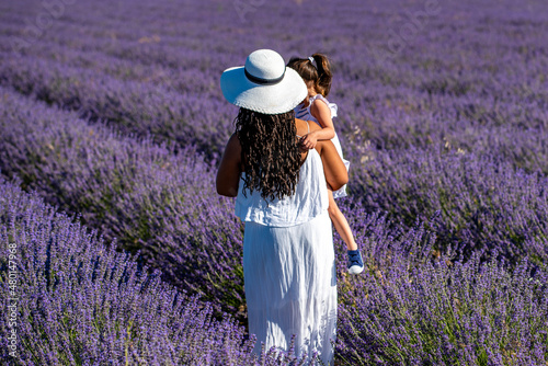 Fototapeta Naklejka Na Ścianę i Meble -  Woman and daughter in a field of lavender flowers