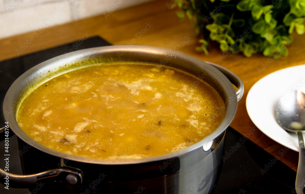 selective focus on lentil and pea soup in a steel pot on the hob selective focus on lentil and pea soup in a steel pot on the hob