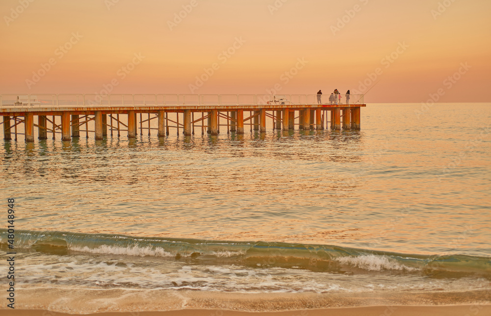 Seascape at sunset. Golden sunrise on the sandy beach. 