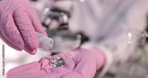 Scientist pours liquid mercury onto gloved hand