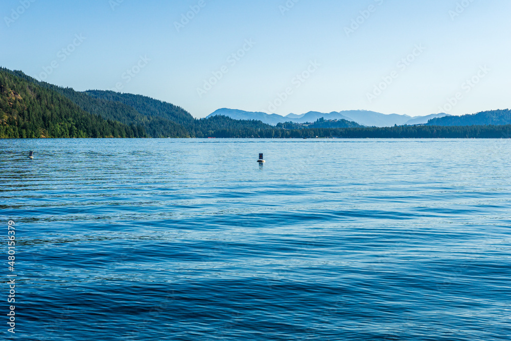 Cultus lake blue water with clear sky and mountains in the distance summer time