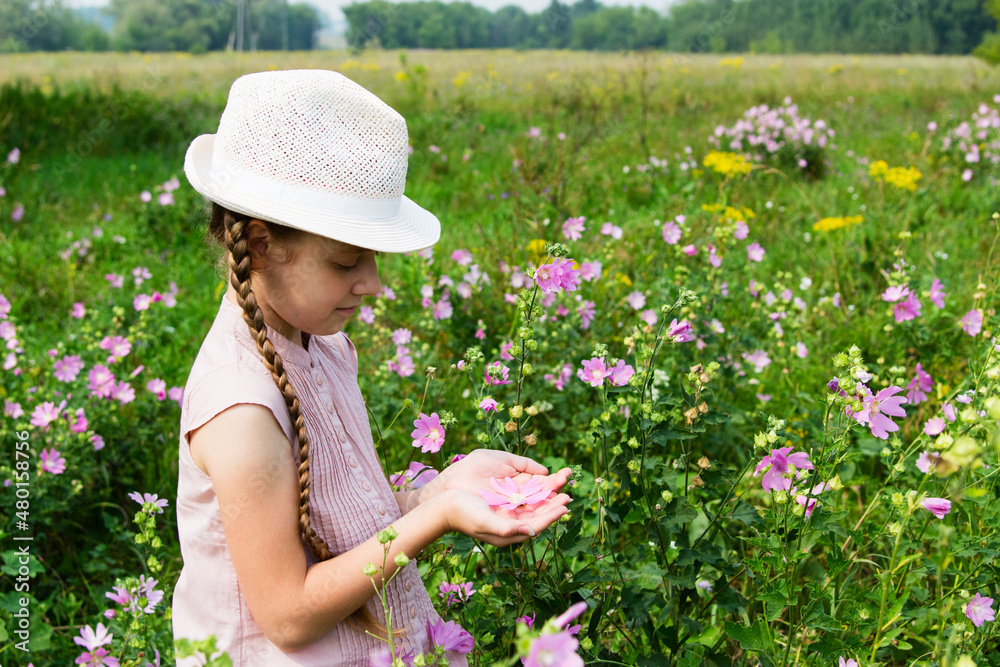Girl on the meadow with flowers.