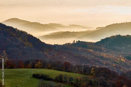 Beautiful mountain landscape with hills in the fog. Morning light at sunrise. Late autumn. Protected area Vrsatec, Slovakia.