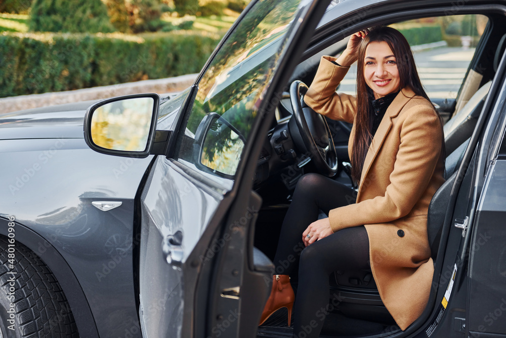 Woman is sitting in modern black colored automobile Woman is sitting in modern black colored automobile