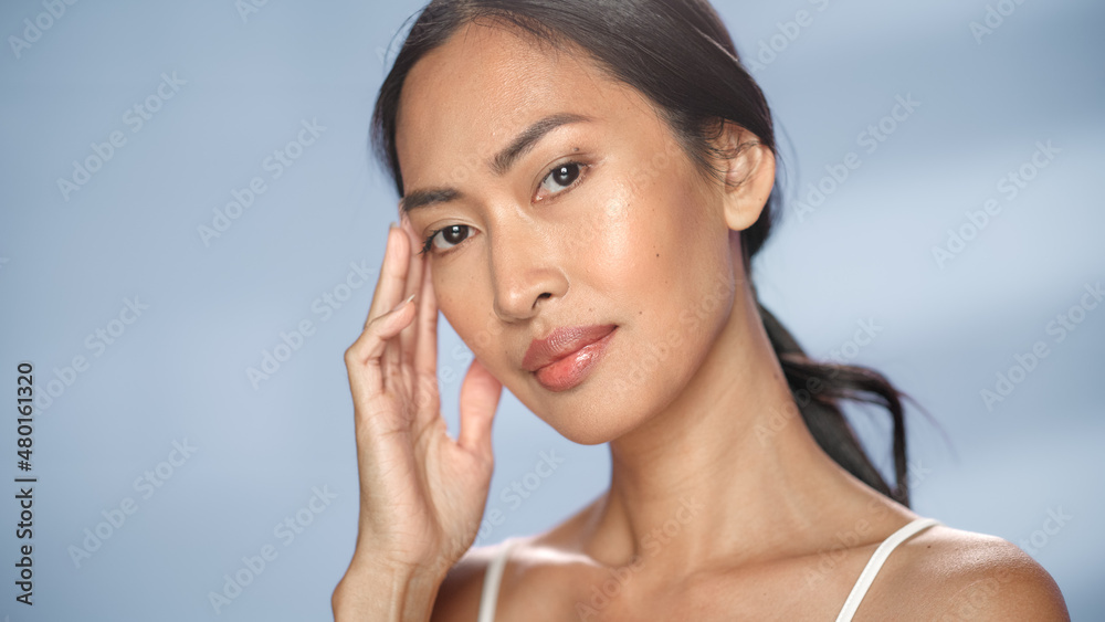 Female Beauty Portrait. Beautiful Asian Happy Brunette Woman Posing, Touching Her Face with Natural, Healthy Skin. Wellness and Skincare Concept on Soft Isolated Background. Close Up. Female Beauty Portrait. Beautiful Asian Happy Brunette Woman Posing, Touching Her Face with Natural, Healthy Skin. Wellness and Skincare Concept on Soft Isolated Background. Close Up.