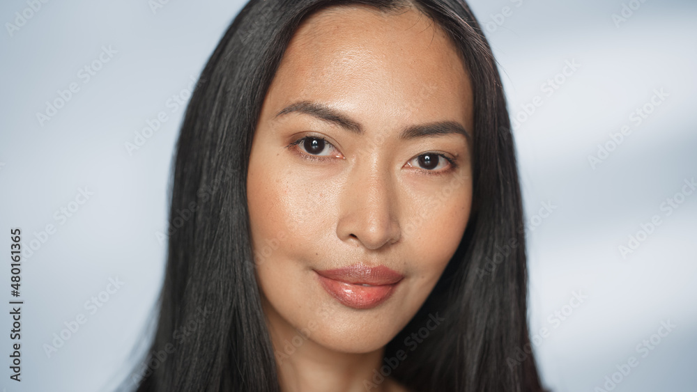 Female Beauty Portrait. Beautiful Asian Happy Brunette Woman Posing, Touching Her Face with Natural, Healthy Skin. Wellness and Skincare Concept on Soft Isolated Background. Close Up. Female Beauty Portrait. Beautiful Asian Happy Brunette Woman Posing, Touching Her Face with Natural, Healthy Skin. Wellness and Skincare Concept on Soft Isolated Background. Close Up.
