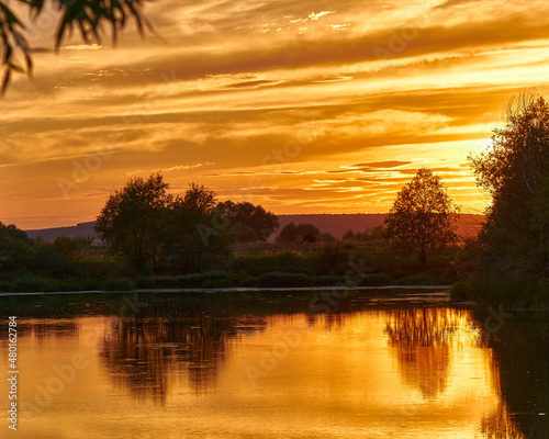 Beautiful sunset on the river bank. Sunset river landscape. River at sunset. Red sunset river