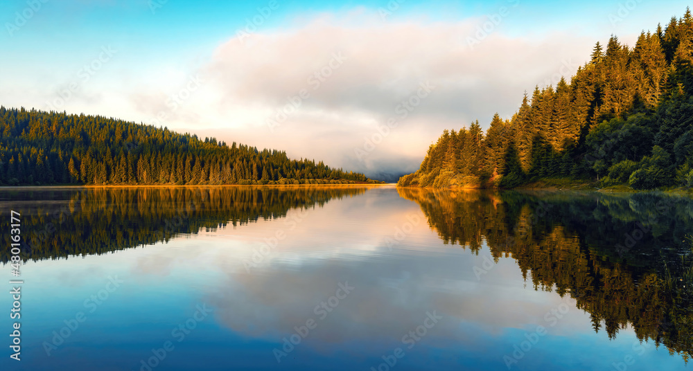 Early morning mountain lake scenery with fog and colorful sky, springtime	