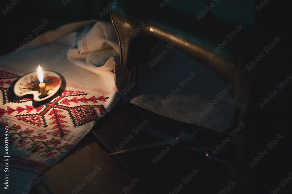 Antique sewing machine, embroidered towel and candle light
