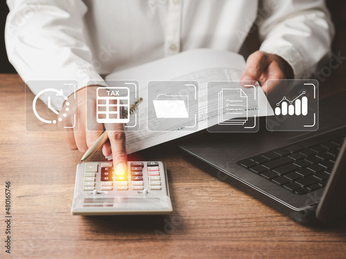 Tax day concept. Tax payment and calculation tax return. Businessman using a calculator and complete individual income tax payment form photo