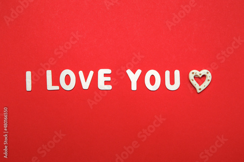 I Love You latin inscription. Wooden alphabet letters isolated on red background. St. Valentine`s Day February holiday winter decorated quote words text. Creative greering card title 