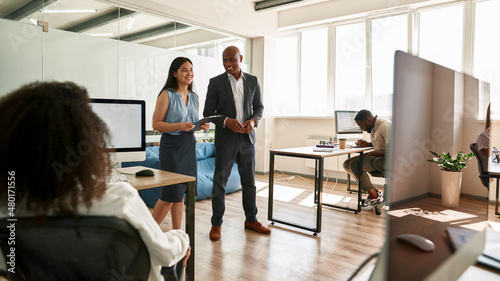 Employees looking on boss and assistant at meeting