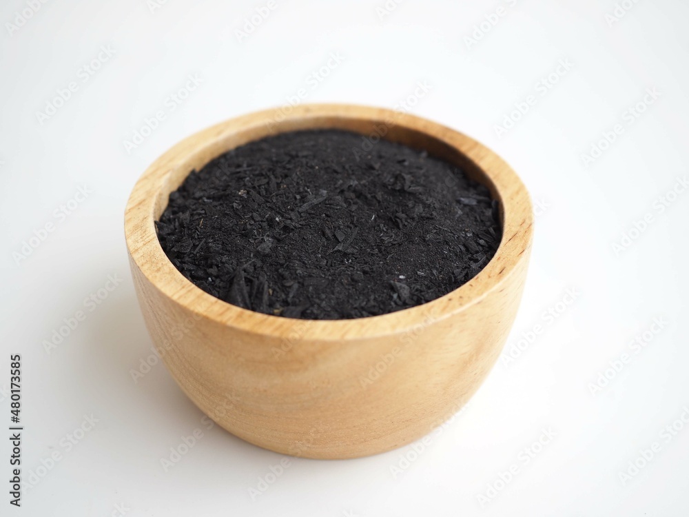 Charcoal powder in wooden bowl isolate on white background. closeup photo. Charcoal powder in wooden bowl isolate on white background. closeup photo.