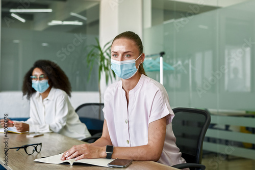 Employees listen and look on colleague at meeting