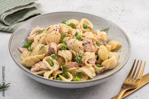 Orecchiette pasta with smoked salmon, green peas, creamy sauce and dill. Healthy food.
