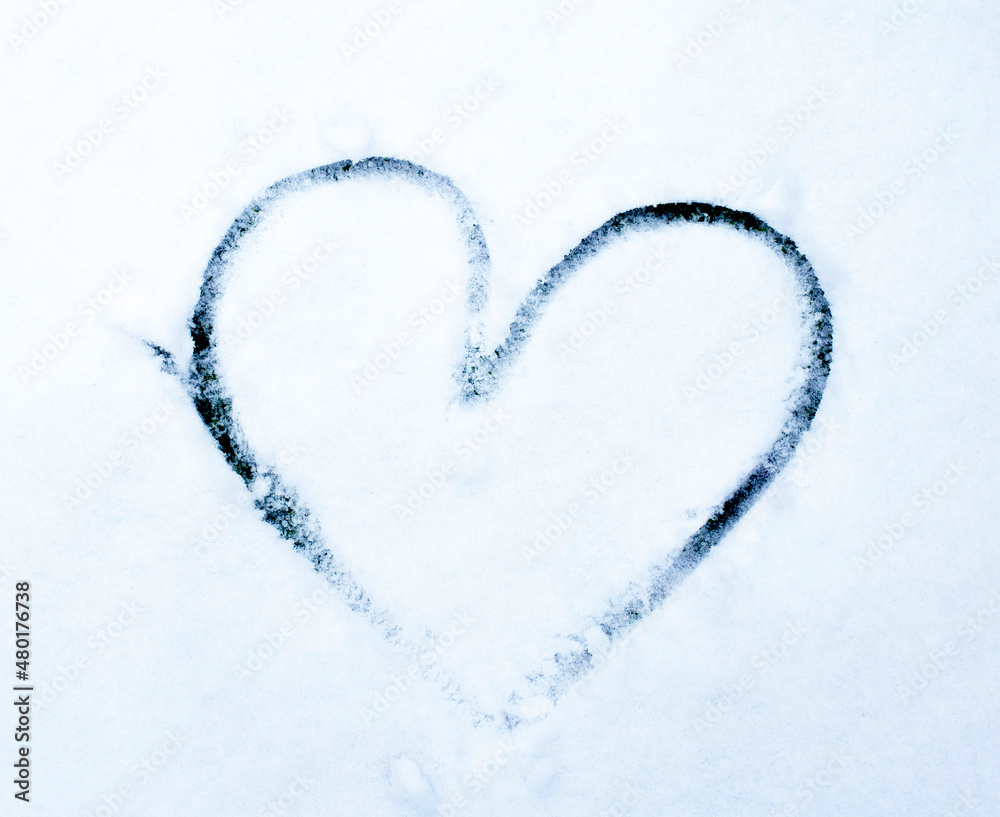 Snow hand drawn shape heart painted in the snow. Winter. Copy space. Love concept
