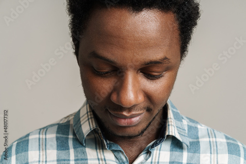 Slika na platnu Black unshaven man in plaid shirt posing and looking downward