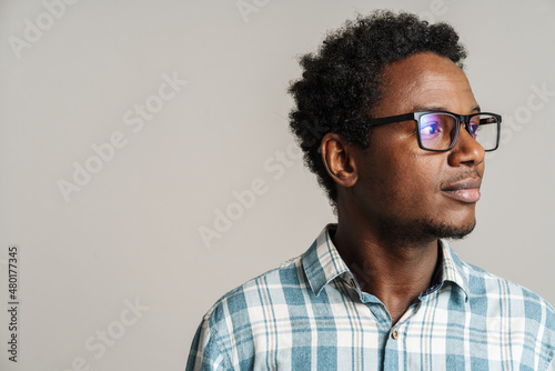 Fototapeta Young black man wearing eyeglasses posing and looking aside