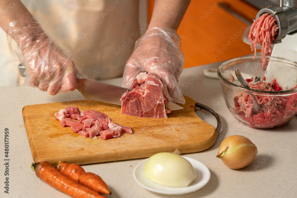 female hands cutting meat for minced meat