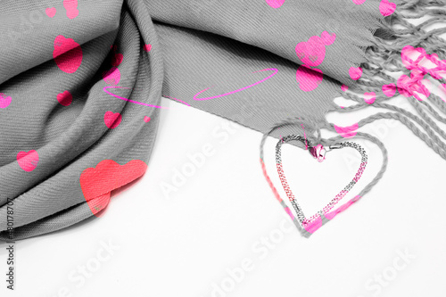 Gray scarf on a white background with bright spots and a heart bracelet. Valentine's day concept, congratulation.