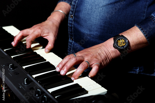 elderly man with long gray hair plays the keys. hands closeup