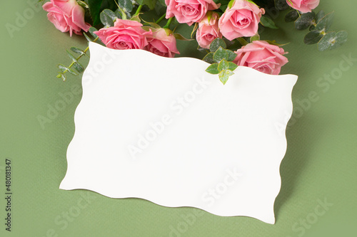 Greeting card with pink roses and empty white blank, green background. Template for Valentine's day, Mother's day, wedding, birthday, greeting board, spring banner for sale and advertyising