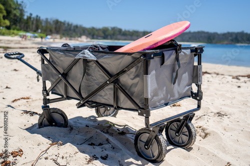 Outdoor beach cart wagon on a sandy beach near the ocean. Family vacation holidays photo