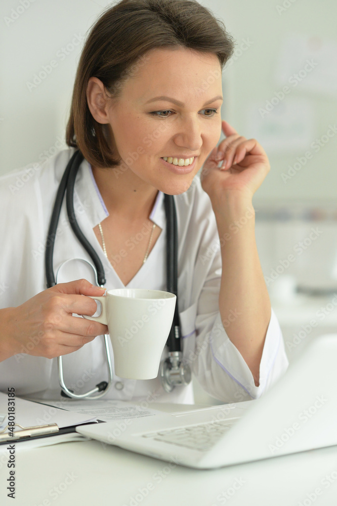 Portrait of smiling female doctor with tea in hospital Portrait of smiling female doctor with tea in hospital