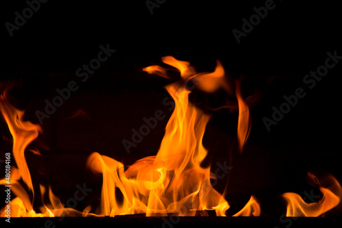 Bright orange bonfire flame on a black background. Abstract fiery texture. Realistic flame of fire burns the motion frame. Texture for design. The texture of fire. A blazing burning bonfire.