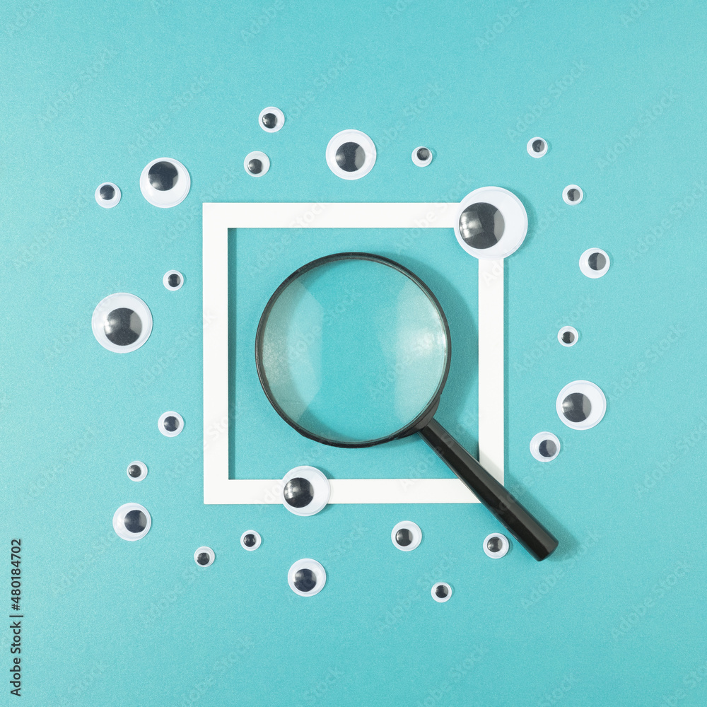 Magnifier and sticker eyes with a frame on a turquoise background. Search for truth minimal concept. Magnifier and sticker eyes with a frame on a turquoise background. Search for truth minimal concept.