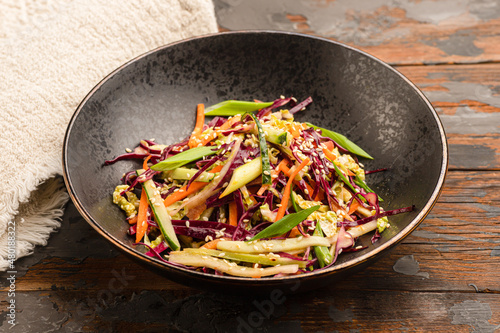 vegetable salad with cabbage and herbs on a wooden background
