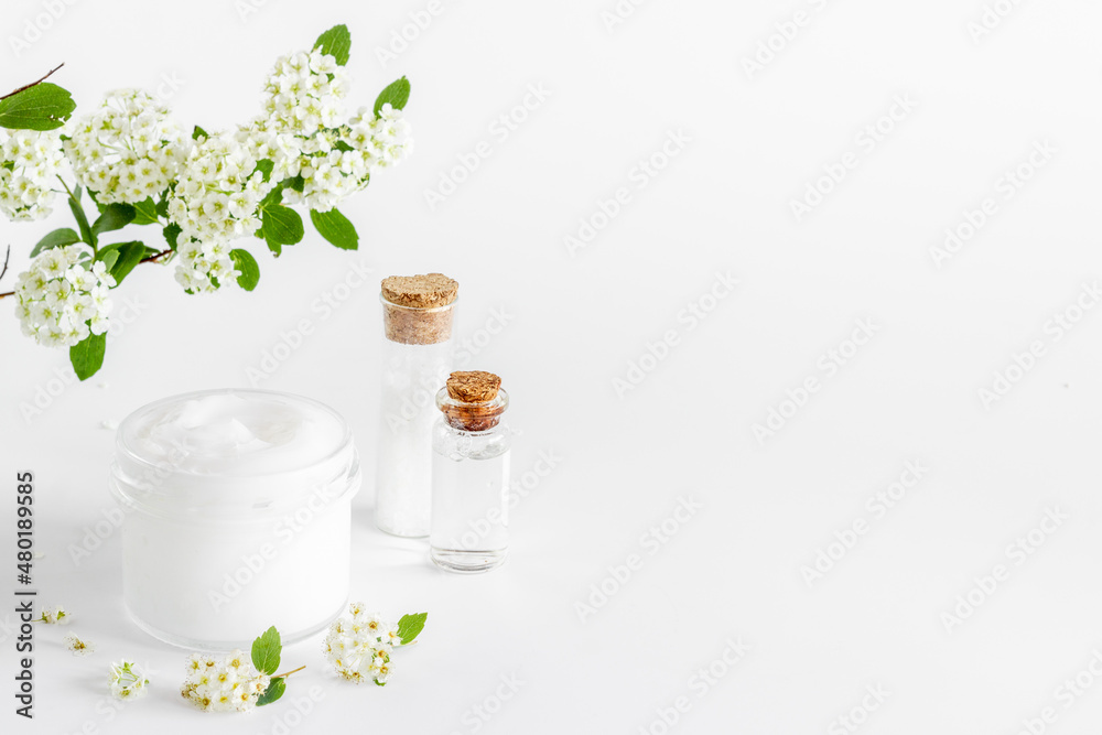 White moisturizing cream cosmetic for spa treatment with blossoms flowers White moisturizing cream cosmetic for spa treatment with blossoms flowers
