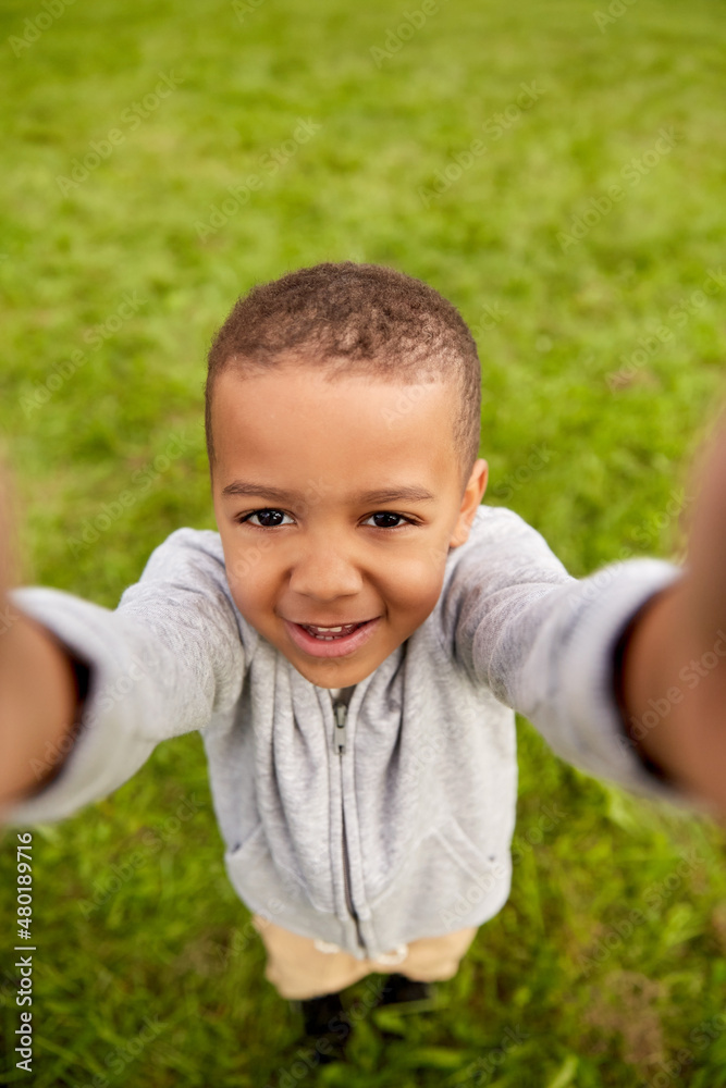 childhood, emotion and people concept - happy smiling little boy taking selfie at park childhood, emotion and people concept - happy smiling little boy taking selfie at park
