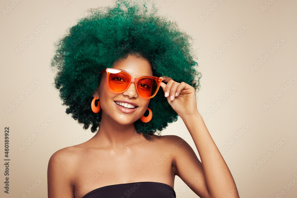 Beauty portrait of African American girl in colored sunglasses. Beautiful black woman. Cosmetics, makeup and fashion. Dyed afro hair