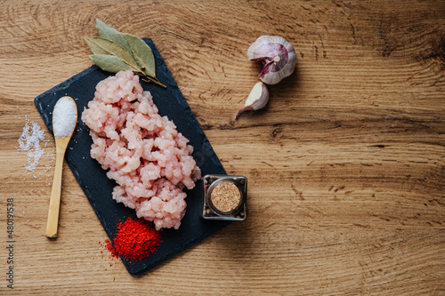 raw minced fresh meat on a wooden background spice pepper wooden spoon
