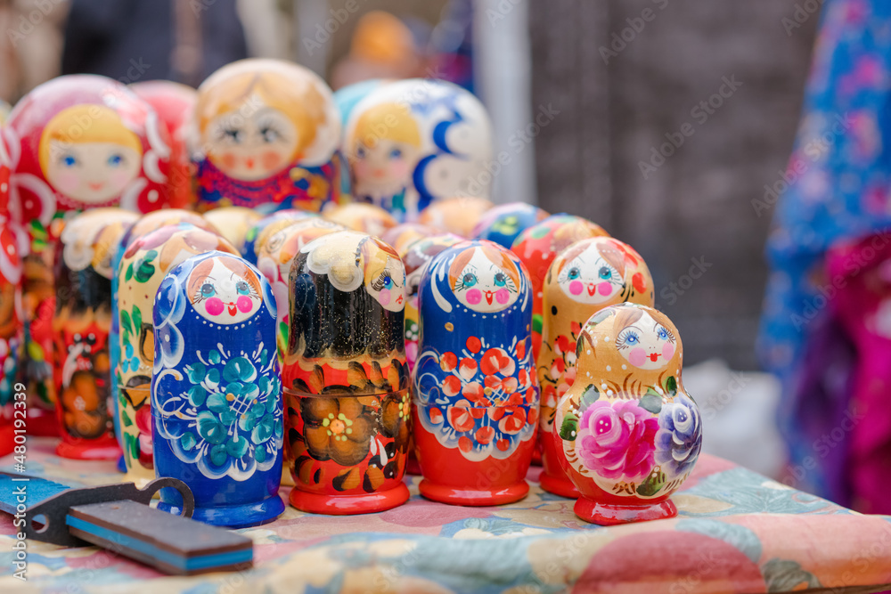 Different traditional wooden russian dolls matryoshka on flea market. Souvenir dolls in market stall, collectibles memorabilia concept