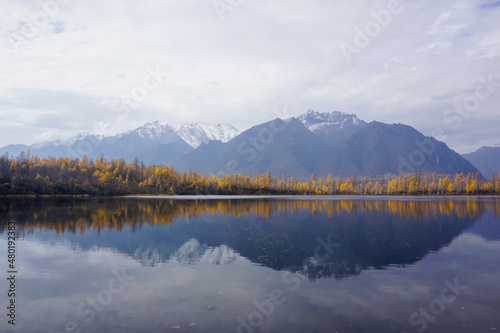 Mountain lake in the taiga and Kodar ridge