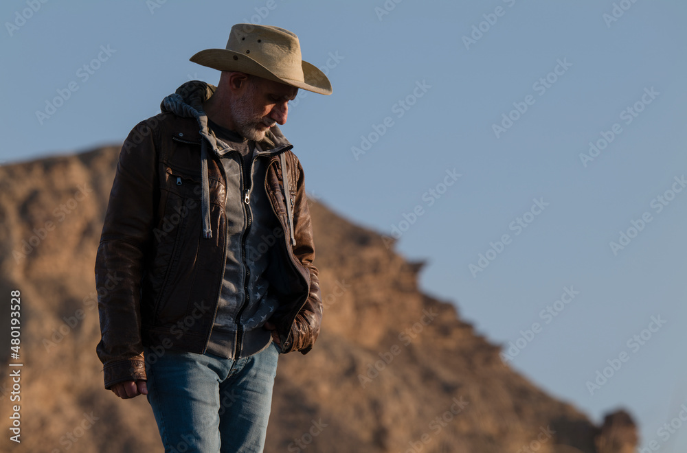 Naklejka premium Adult man in cowboy hat in Tabernas Desert, Almeria, Spain